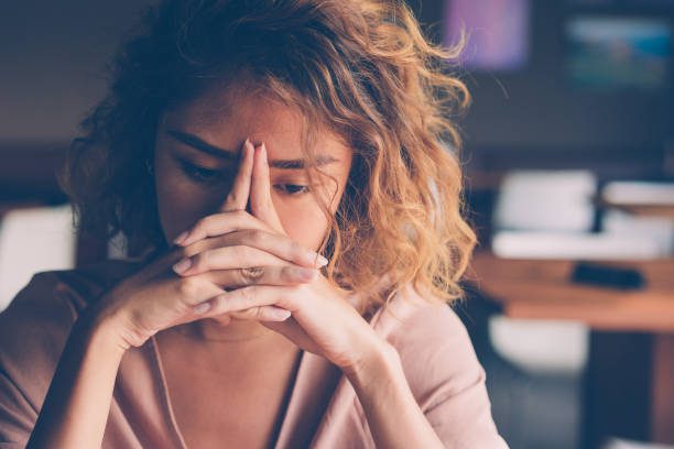 A woman with her hands in front of her face.