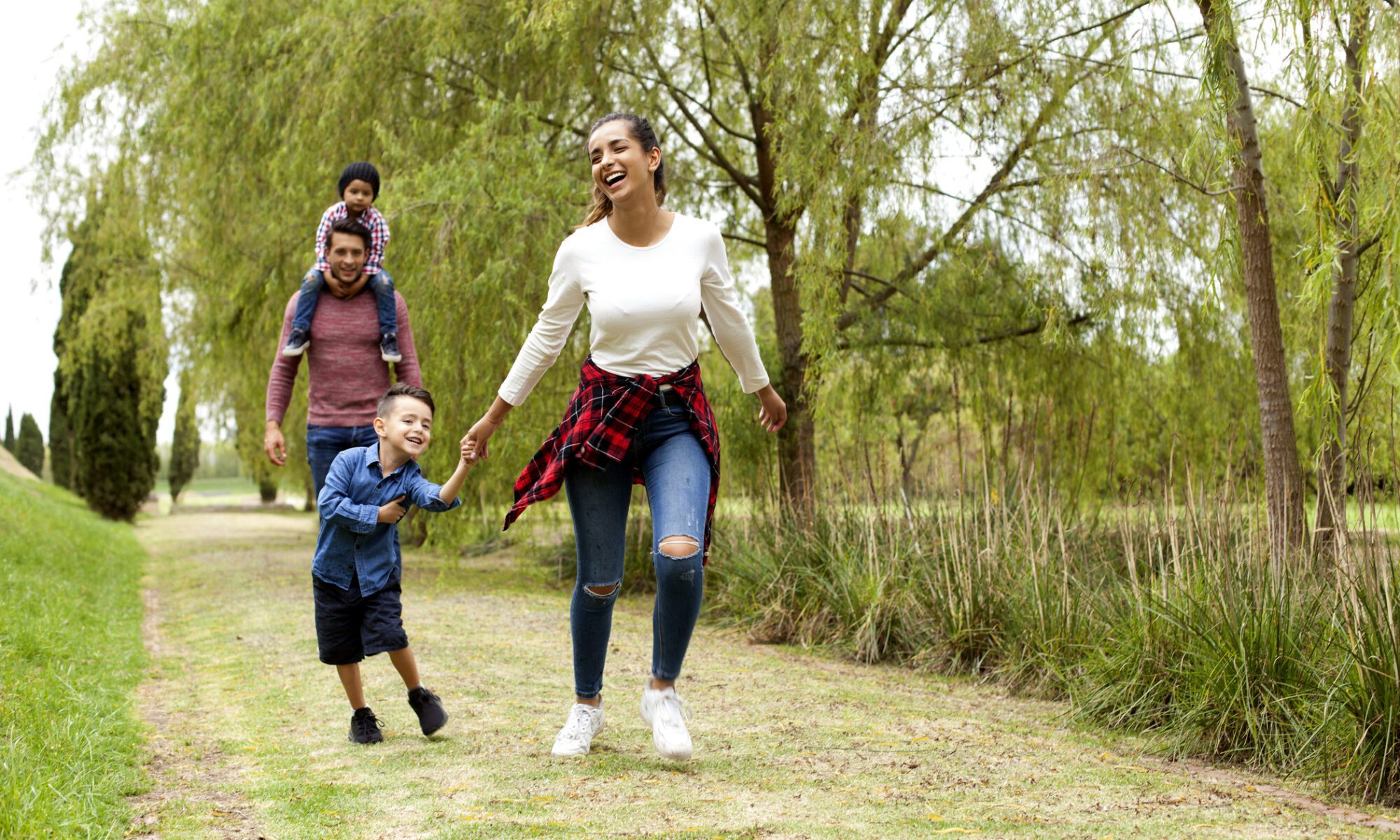 A woman and two children are walking in the park.